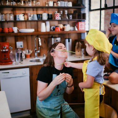 A Woman Playing with her Children in a Kitchen