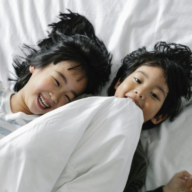 Kids Lying on White Bed