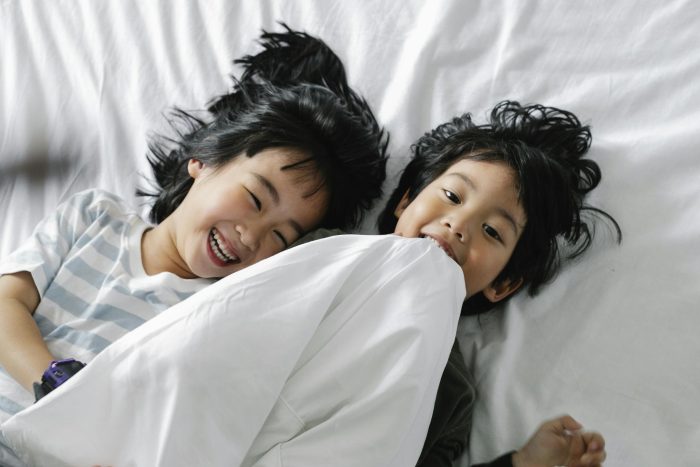 Kids Lying on White Bed