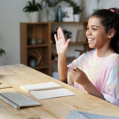 Woman in Pink Shirt Sitting by the Table While Smiling